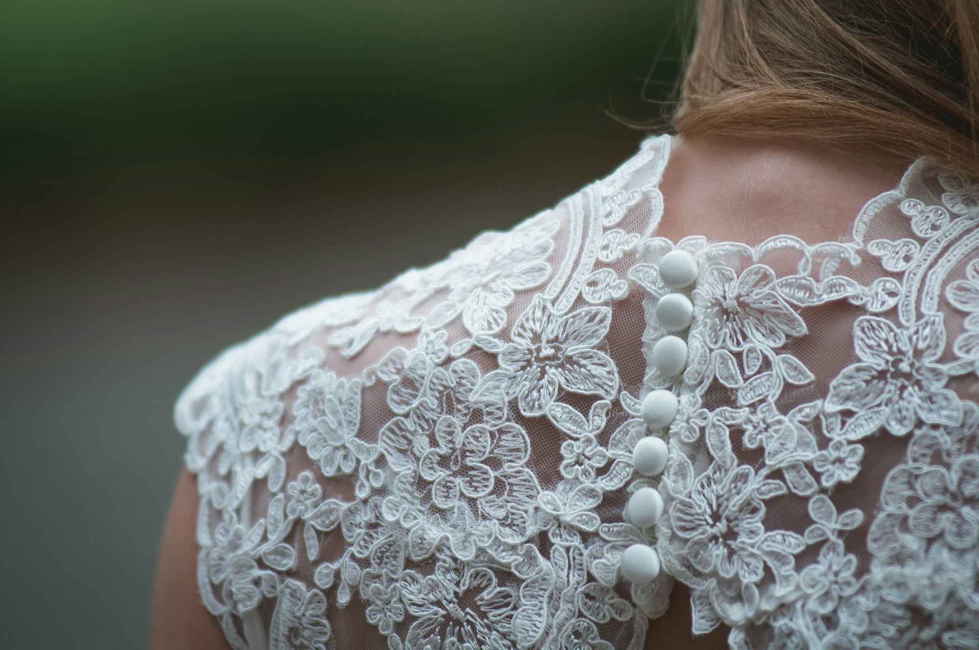 Covered buttons running down the back of a lace wedding dress